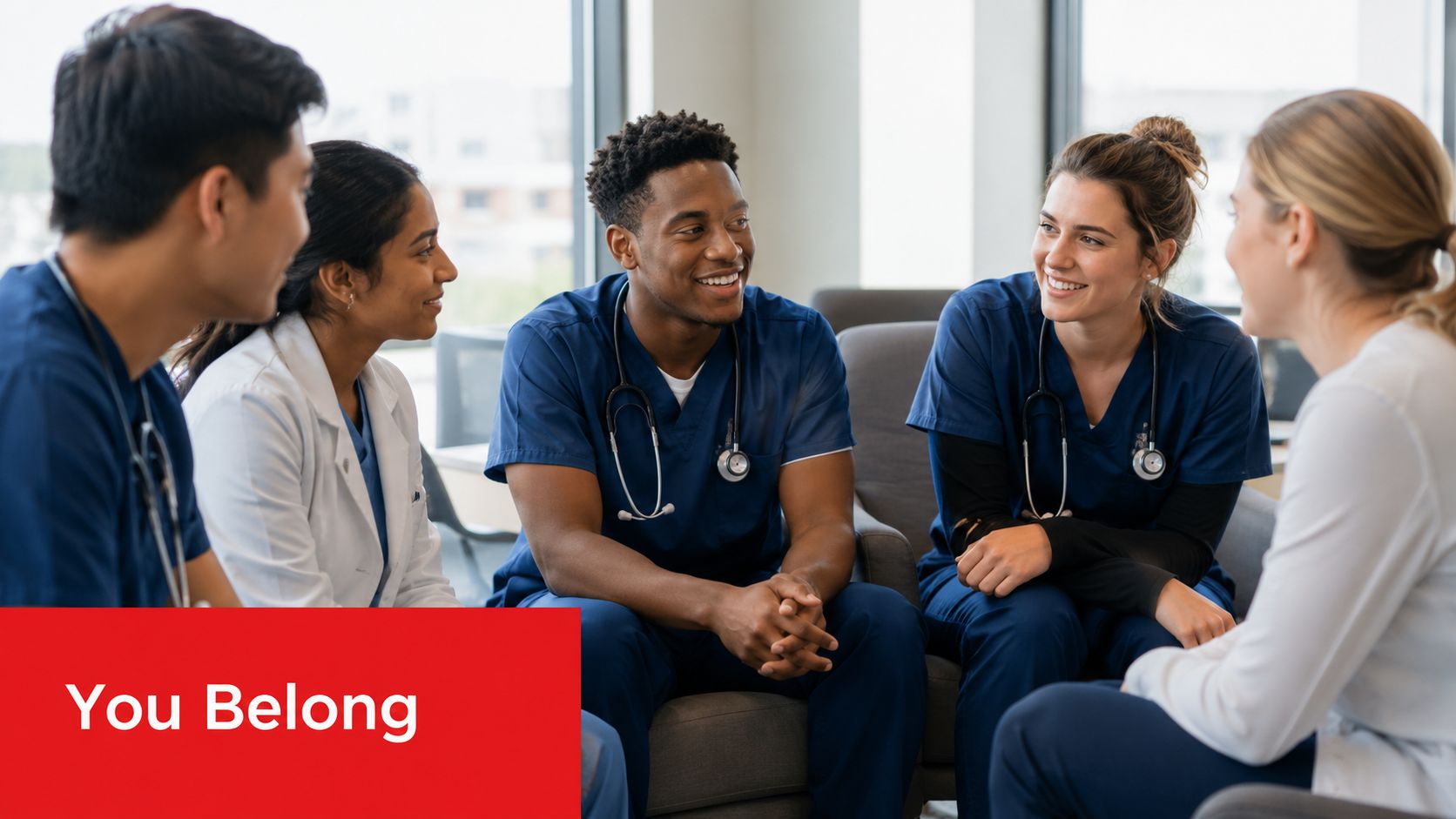 A diverse group of medical students in scrubs having a friendly conversation in a bright hospital lounge.