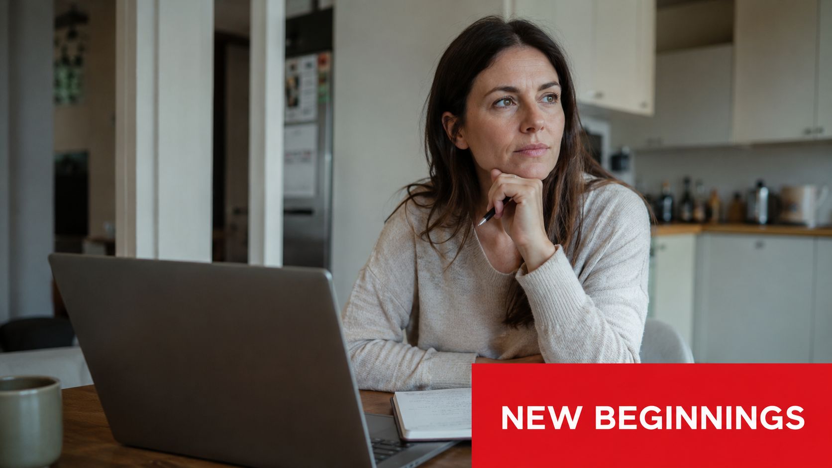 A woman thinking while working on her laptop with a notebook on a kitchen table.